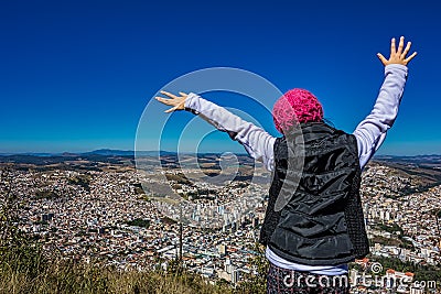 Photo of girl with open arms on trail in the mountain with the city of Pocos de Caldas in Minas Gerais - Brazil Editorial Stock Photo
