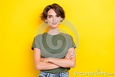 Photo of girlish pretty confident nice girl with bob hairstyle wear khaki t-shirt arms crossed isolated on yellow color Stock Photo