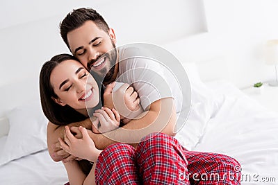 Photo of good mood adorable boyfriend girlfriend sleepwear hugging indoors home bedroom Stock Photo