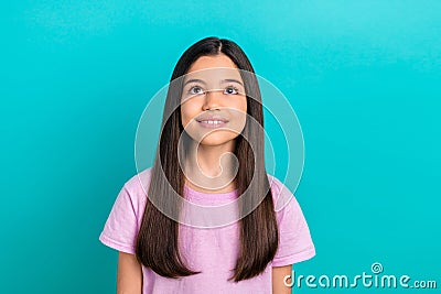 Photo of good mood dreamy small kid wear pink t-shirt looking up empty space isolated turquoise color background Stock Photo
