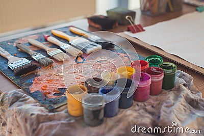 Photo of gouache and watercolor with brushes set in art studio. Oil paints smeared on palette Stock Photo