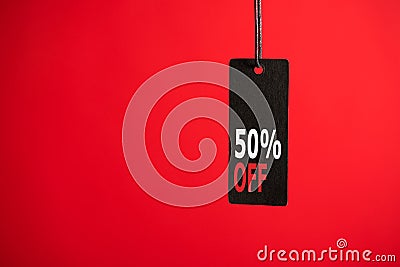 Photo of hanging black price tag on isolated red background with text 50% off Stock Photo