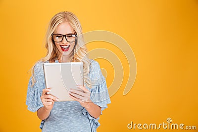 Happy young blonde woman using tablet computer. Stock Photo