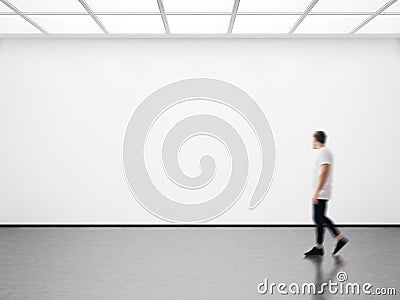 Photo of hipster in modern gallery looking at the empty canvas. Blank mockup, motion blur Stock Photo