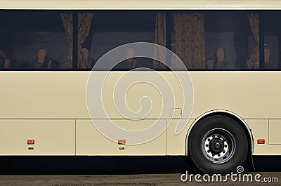 Photo of the hull of a large and long yellow bus with free space for advertising. Close-up side view of a passenger vehicle for t Stock Photo