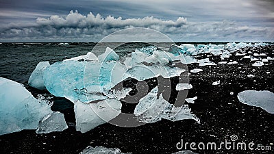 Photo of icebergs cast away on dark beach Stock Photo
