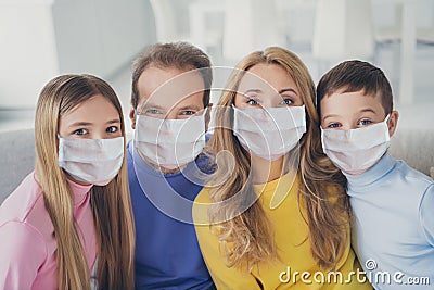 Photo of idyllic family mom dad and two children boy girl look in camera toothy smile sit couch in house indoors Stock Photo