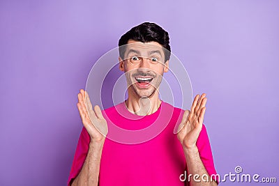 Photo of impressed excited young guy dressed pink t-shirt rising arms open mouth isolated violet color background Stock Photo
