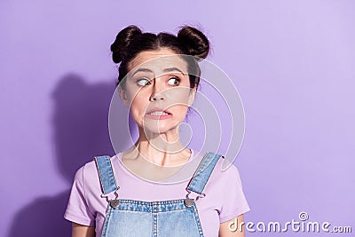Photo of impressed guilty young woman dressed denim overall looking empty space isolated purple color background Stock Photo
