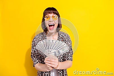 Photo of impressed young lady hold money open mouth wear eyewear leopard shirt isolated on yellow color background Stock Photo