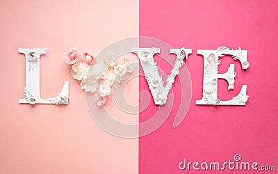 Photo inscription love made of leaves and flowers on pink background Stock Photo