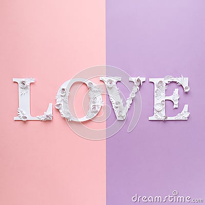 Photo inscription love made of leaves and flowers on pink and purple background Stock Photo