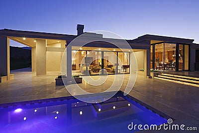 View inside modern home with swimming pool at dusk Stock Photo