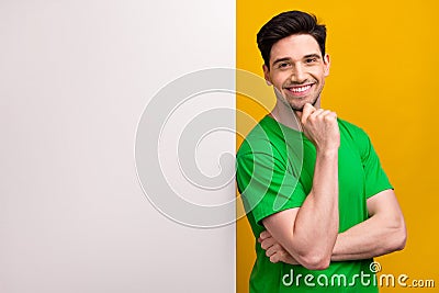 Photo of intelligent man dressed green t-shirt stand near board empty space think business ideas isolated on yellow Stock Photo