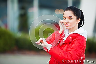 Photo of Joyful Fitness Woman 30s in Sportswear Touching Bluetooth Earpod and Holding Mobile Phone, While Resting in Stock Photo