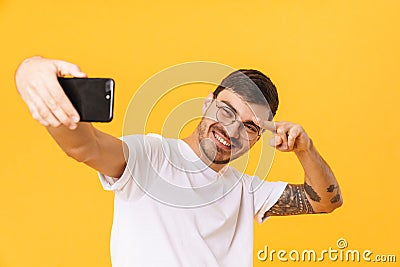 Photo of joyful young man taking selfie and pointing fingers Stock Photo