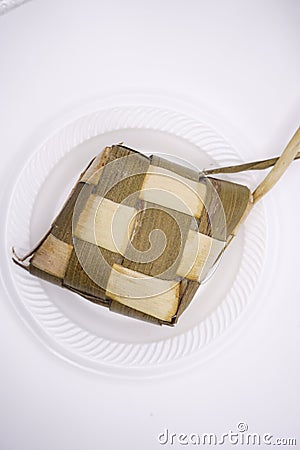 photo of a ketupat on a plastic plate, photographed from above Stock Photo