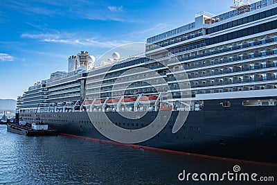 Photo of large cruiser ship docked in deep blue water in Vancouver port BC. Luxury Cruise ship in Vancouver harbour Editorial Stock Photo