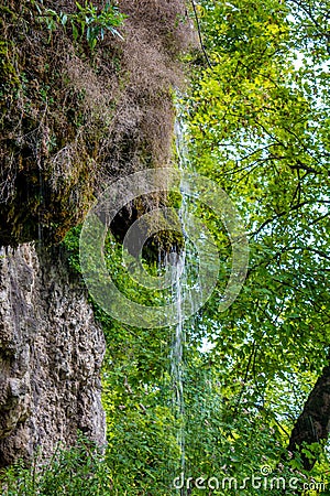 Photo of little waterfall flowing in cave Stock Photo