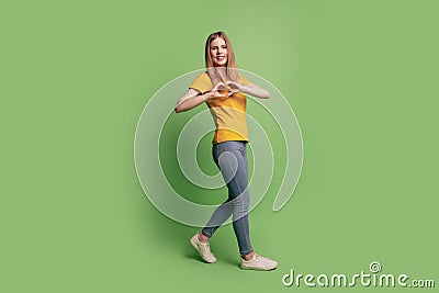 Photo of lovely dream blonde lady show like symbol with fingers walk wear casual outfit on green background Stock Photo