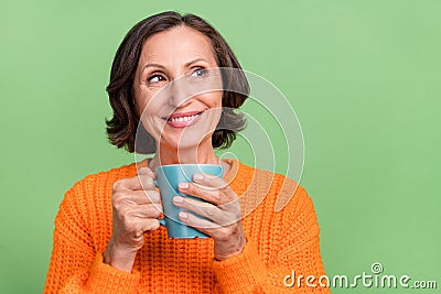 Photo of lovely retired woman interested curious look empty space drink latte espresso isolated over green color Stock Photo