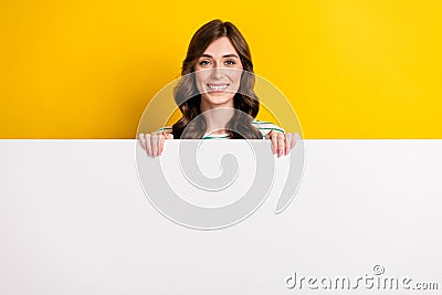 Photo of lovely satisfied woman with curly hairstyle wear striped shirt hold billboard presenting sale on Stock Photo