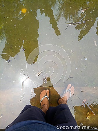 photo of a man's feet soaking in water Stock Photo