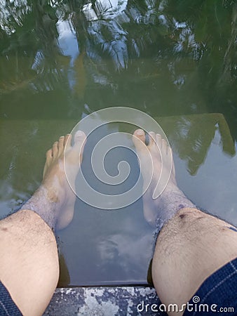 photo of a man's feet soaking in water Stock Photo