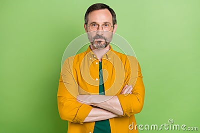 Photo of mature business man serious crossed hands confident wear eyeglasses isolated over green color background Stock Photo