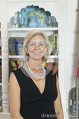 Portrait of mature female shop owner smiling Stock Photo