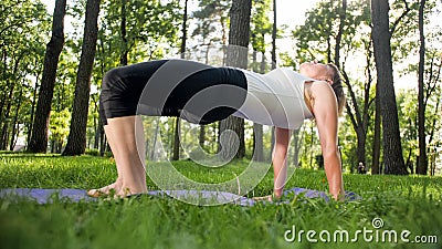 Photo of middle aged smiling woman practising yoga asana. Persong meditating in nature. Balance and harmony of body and Stock Photo