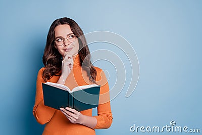 Photo of minded clever creative woman read book finger chin look empty space posing on blue background Stock Photo