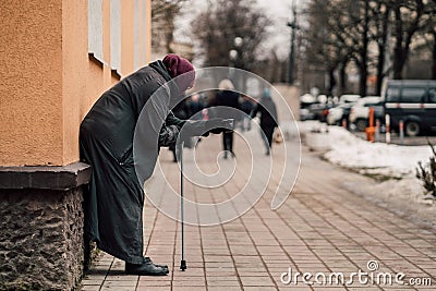 Photo of old hungry homeless female beggar beg for alms and on street. Editorial Stock Photo