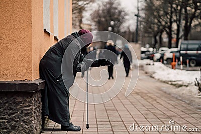 Photo of old hungry homeless female beggar beg for alms and on street. Stock Photo