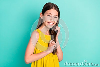 Photo of optimistic nice brown hair girl hands hair wear yellow dress isolated on bright teal color background Stock Photo