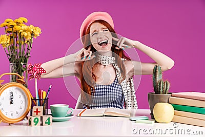 Photo of outraged student girl plugging her ears with fingers while doing homework Stock Photo