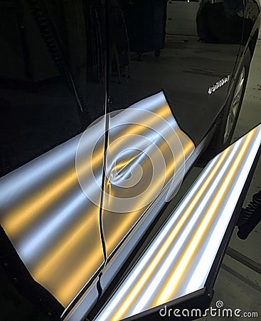 A photo of a paintless dent repair light showing a large crease in a door Stock Photo