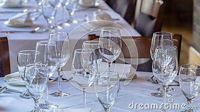 Photo Panorama Wine glasses spoons forks saucer plates and napkins on a table with white cloth Stock Photo