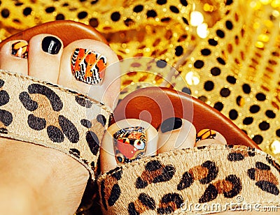 Photo of pedicure like butterfly design on gold background close up, mani pedi creative concept Stock Photo