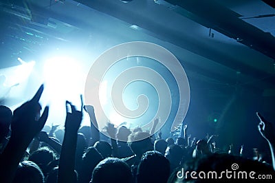 Photo of people having fun at rock concert, fans applauding to famous music band, rock star on the stage. Stock Photo