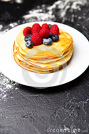 Photo of plate with pancakes, blueberries, raspberries dusted with icing sugar Stock Photo