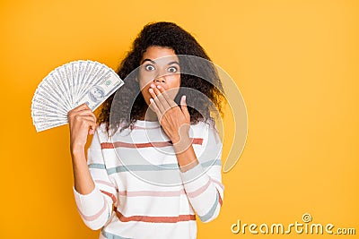 Photo portrait of astonished speechless voiceless quiet girl closing her mouth with palm holding stack of american money Stock Photo