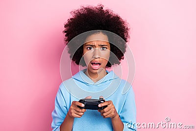 Photo portrait of charming little girl disappointed hold joystick lose game wear trendy blue garment isolated on pink Stock Photo