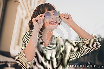 Photo portrait female student in striped shirt smiling overjoyed having nice mood in sunny weather wearing stylish Stock Photo