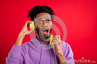 Photo portrait man listening music in headphones dissatisfied isolated vibrant red color background Stock Photo