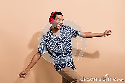 Photo portrait of nice young male dancing disco headphones wear trendy blue print garment isolated on beige color Stock Photo