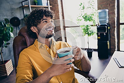 Photo portrait of nice young male wear yellow shirt pause coffee breakfast comfort work table living room interior loft Stock Photo