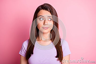 Photo portrait of sceptical woman looking to side on pastel pink colored background Stock Photo