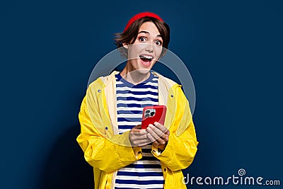 Photo portrait of shocked young blogger traveling norway cold weather booking service internet phone isolated on blue Stock Photo