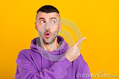 Photo portrait young man wearing purple hoody curious pointing copyspace isolated vibrant yellow color background Stock Photo